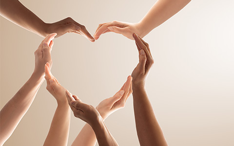 a number of people with different skin tones forming a heart with their hands